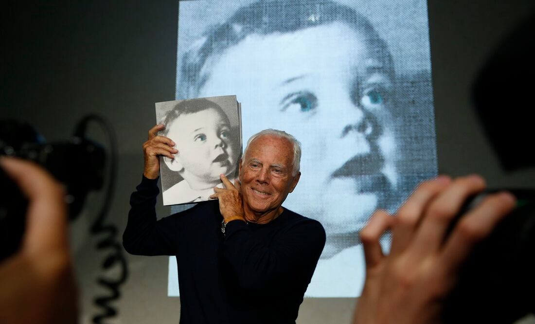 El diseñador Giorgio Armani posa con una copia del libro Giorgio Armani, escrito por la periodista Suzy Menkes, presentado en septiembre de 2015. FOTO: AP