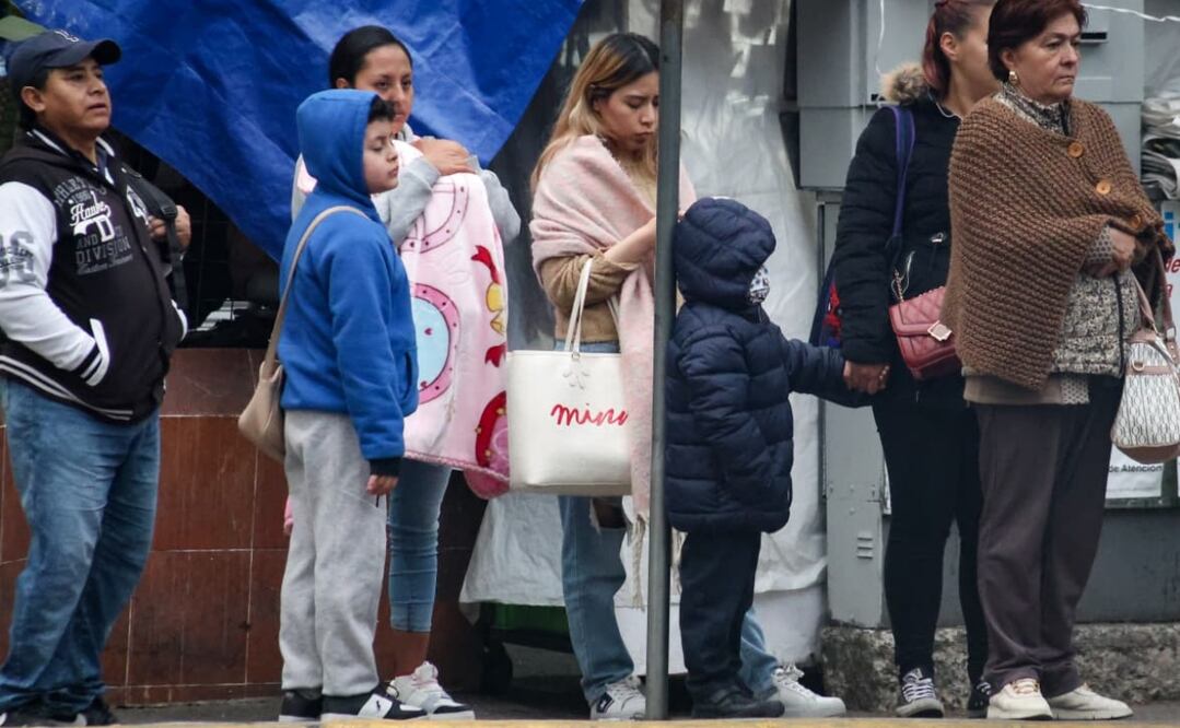 Niños bien abrigados haciendo fila junto a sus madres en espera del transporte público. Foto: Luis Camacho / EL UNIVERSAL