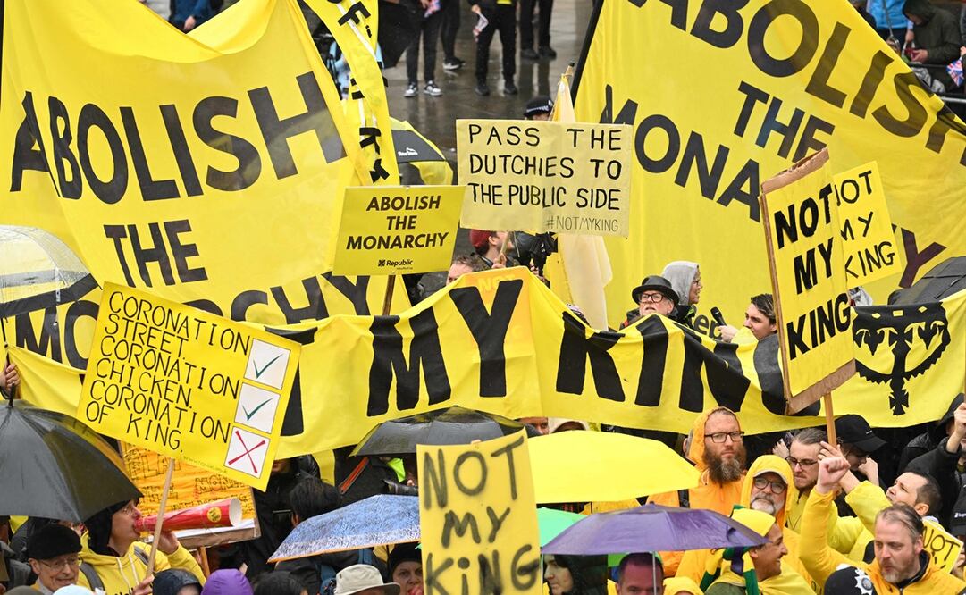Los manifestantes ondean carteles de "No es mi rey" cerca de la 'Procesión del Rey', un viaje de dos kilómetros desde el Palacio de Buckingham hasta la Abadía de Westminster en el centro de Londres el 6 de mayo de 2023, antes de sus coronaciones.Foto de SEBASTIEN BOZON / PISCINA / AFP