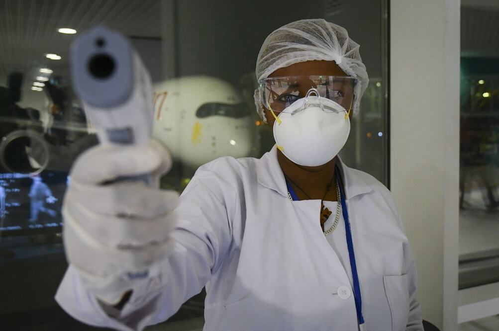 Un trabajador de la salud posa para un fotógrafo durante un proceso de detección de la infección por coronavirus en el Aeropuerto Internacional de Etiopía. Foto: EFE