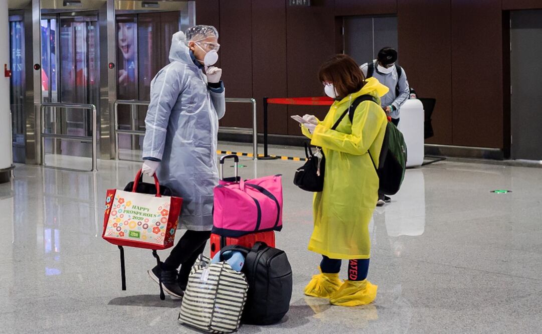 This picture taken on February 14, 2020 shows travellers wearing protective gear at an airport – Photo: Nicola Afouri/AFP