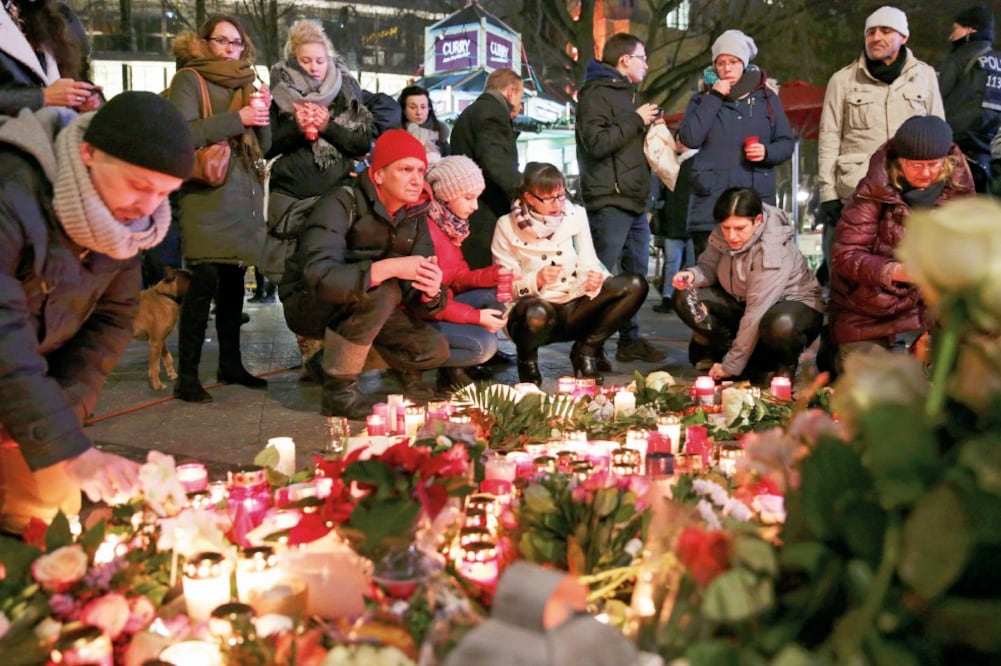 Cientos de alemanes encendieron velas y pusieron flores ayer en el mercado de Navidad en Berlín, en memoria de las 12 personas que murieron en el ataque perpetrado el lunes en ese lugar. (CHRISTIAN MANG. REUTERS)