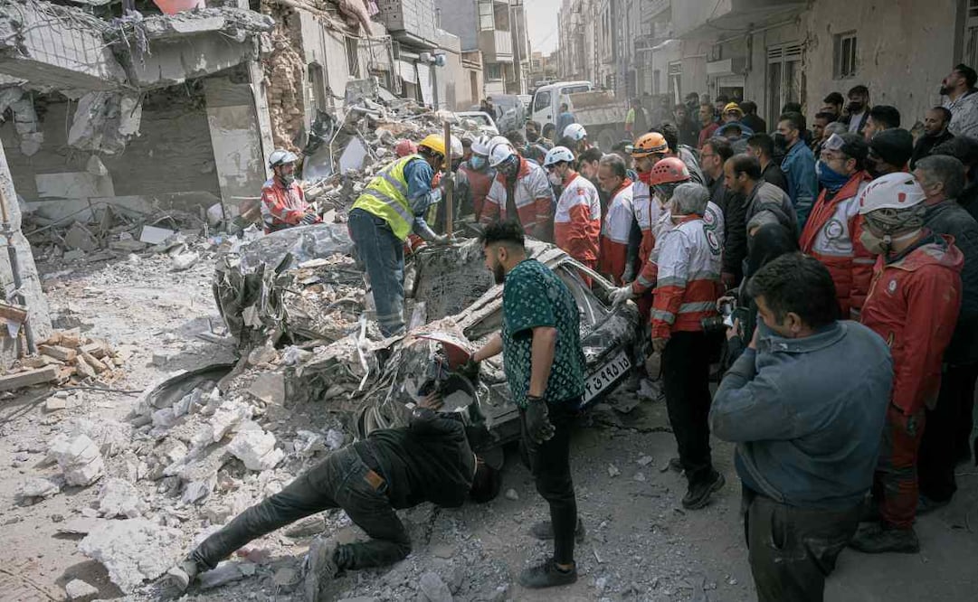 Equipos de emergencias inspeccionan un auto destruido en las inmediaciones de un edificio residencial atacado durante la noche en la campaña militar israelí-estadounidense en Tabriz, en la provincia de Azerbaiyán Oriental, en el noroeste de Irán, el 24 de marzo de 2026. Foto: AP