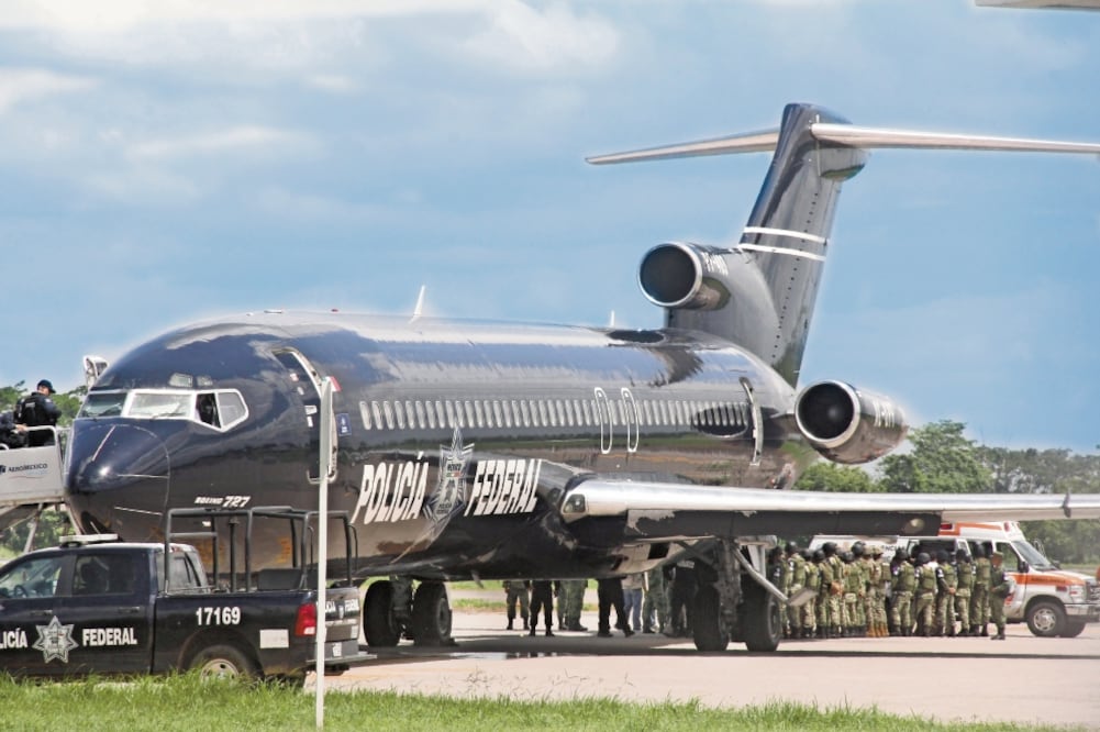 Elementos de la Guardia Nacional forman una valla desde la puerta trasera de la aeronave —donde ya se encontraban los haitianos— hasta una ambulancia del grupo de protección al migrante Beta Sur. Foto/MARÍA DE JESÚS PETERS. EL UNIVERSAL