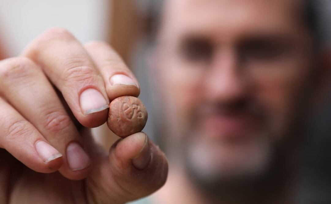 Un arqueólogo muestra la pequeña piedra encontrada en el valle Zurim, cerca de Jerusalén. Foto: EFE/ Abir Sultan