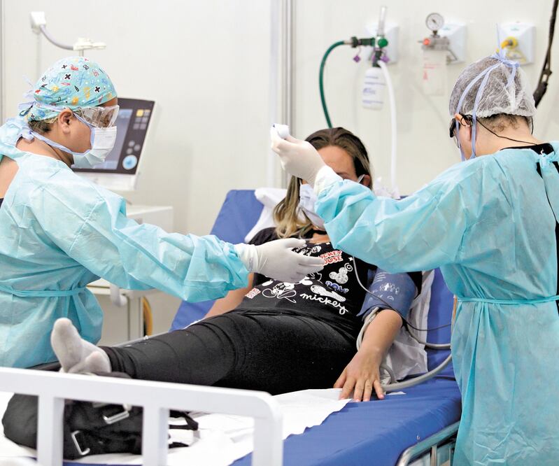 En la Unidad de Emergencia del Núcleo Bandeirantes, en Brasilia, los doctores atendieron a un a mujer con complicaciones respiratorias. LUCIO TAVORA. EFE