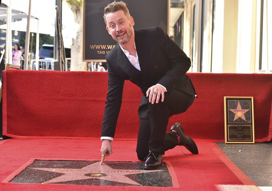 El actor estadounidense Macaulay Culkin señala su recién presentada estrella del Paseo de la Fama de Hollywood durante una ceremonia en Hollywood, California, el 1 de diciembre de 2023. Foto: Frederic J. BROWN / AFP.