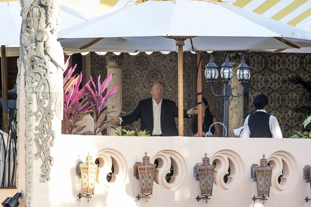 President-elect Donald Trump, center, speaks to an aide at Mar-a-Lago resort, in Palm Beach, Fla., Monday, Dec. 19, 2016. Trump is spending the day in meetings at the resort. (AP Photo/Andrew Harnik)