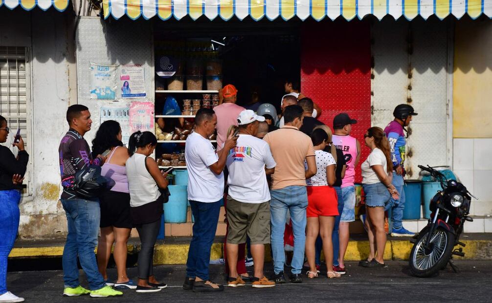 Tras ataque de EU en Venezuela, cientos de comercios permanecen cerrados por lo que venezolanos hacen filas para comprar comida en donde se pueda. FOTO: Jacinto Oliveros / AFP