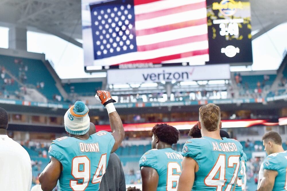 Robert Quinn (94), de los Dolphins, levantó el puño durante la ceremonia. (Jasen Vinlove, USA Today Sports)