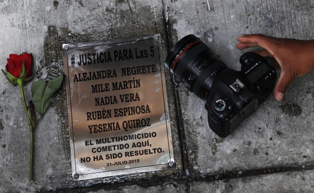 A photographer places his camera next to plaque with the names of photojournalist Ruben Espinosa and four women murdered in an apartment in Mexico City in 2015 - Photo: Marco Ugarte/AP
