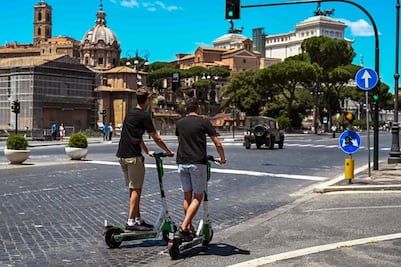 Italianos se transportan en patinetas eléctricas en Roma