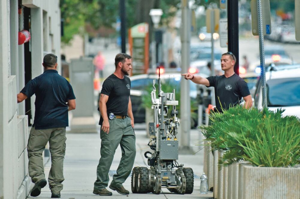 El escuadrón antibombas de la policía investigó en un estacionamiento, cerca del lugar donde ocurrió el tiroteo, en Jacksonville Landing (WILL DICKEY. AP)