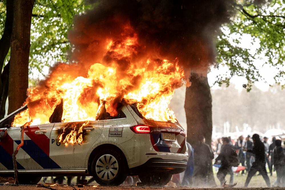 Un coche de policía es incendiado durante una protesta contra la actual política de asilo en Malieveld, La Haya, Países Bajos. Foto: EFE
