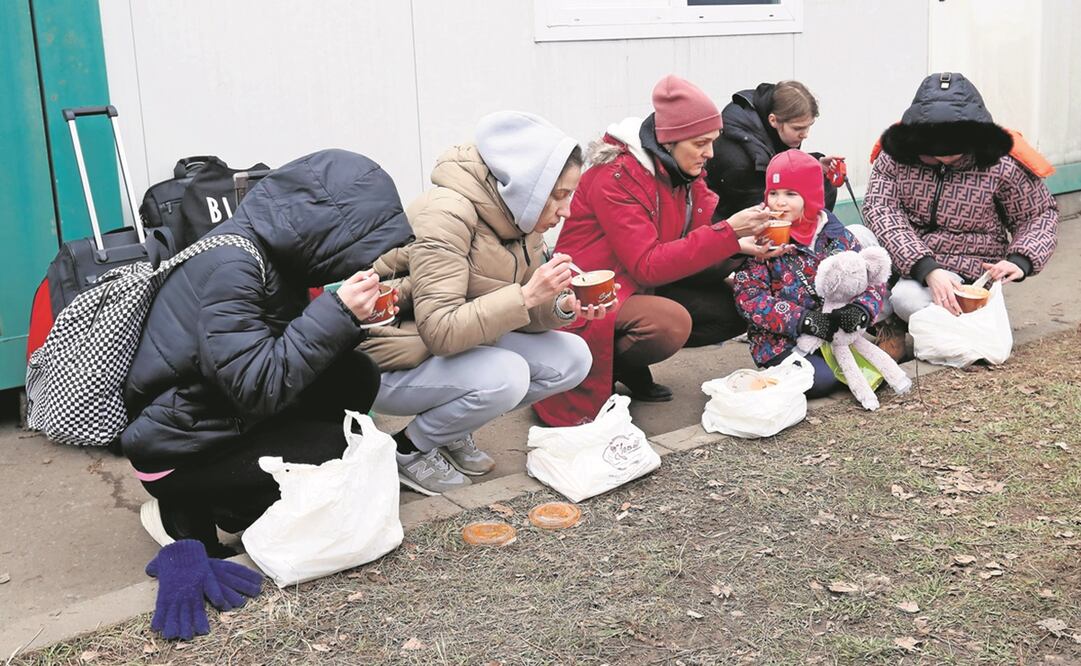 Una familia ucraniana come tras atravesar la frontera con Rumania, en la localidad de Siret. Foto: EFE