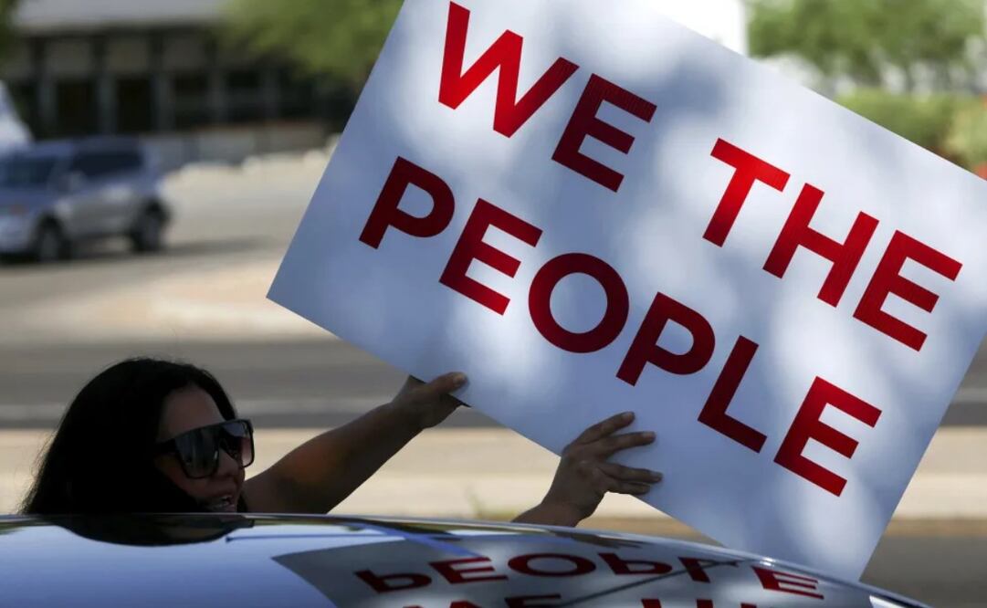 Una mujer sostiene un cartel en medio de una protesta contra el gobierno del presidente Donald Trump en Tucson, Arizona, el 14 de junio del 2025. Foto: AP