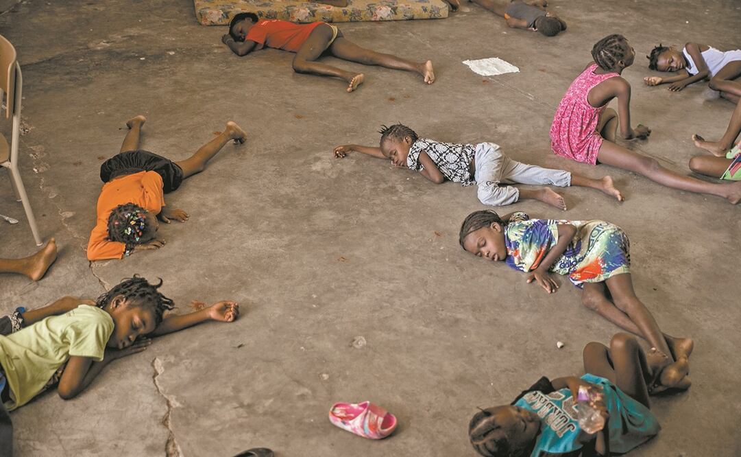 Niños duermen en el piso de una escuela convertida en refugio de haitianos que huyen de la violencia entre pandillas en Cité Soleil, en Puerto Príncipe.
