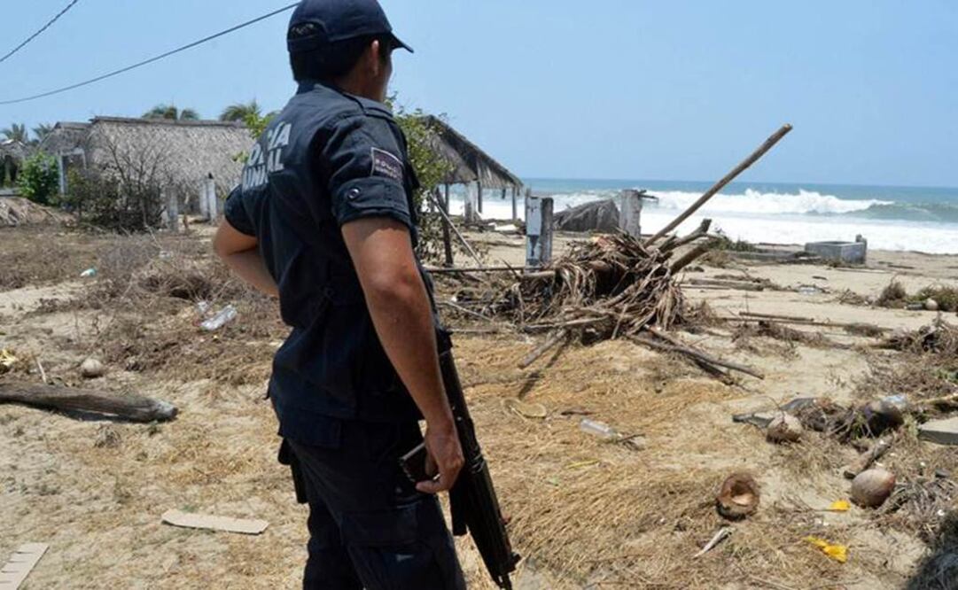 Un policía observa escombros en una playa, luego de las afectaciones causadas por el fenómeno denominado "mar de fondo", en Acapulco, Guerrero