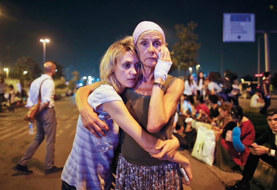 Pasajeras se abrazan mientras esperan ayuda, afuera del aeropuerto internacional de Ataturk, tras los atentados de anoche (EMRAH GUREL. AP)