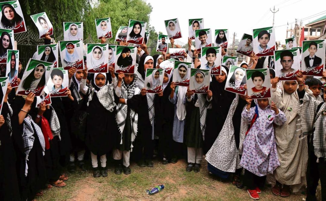 Niñas musulmanas en India sostienen retratos de las menores muertas en un ataque de Estados Unidos contra la escuela Minab, en Irán.