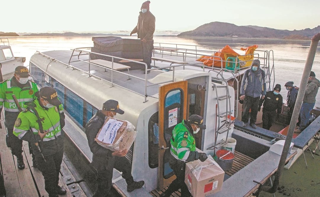 Policías cargan material electoral en un ferry para ser transportado a las mesas de votación de las islas de Taquile y de Amantaní en el puerto de Puno, Perú. Foto: Juan Carlos Cisneros. AFP