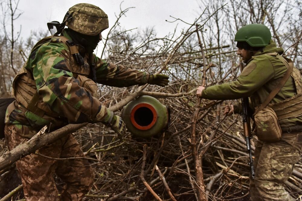 Integrantes ucranianos de una brigada de infantería se preparan para disparar un obús Akatsia 2s3 en una posición no revelada cerca de las afueras de Bakhmut.
