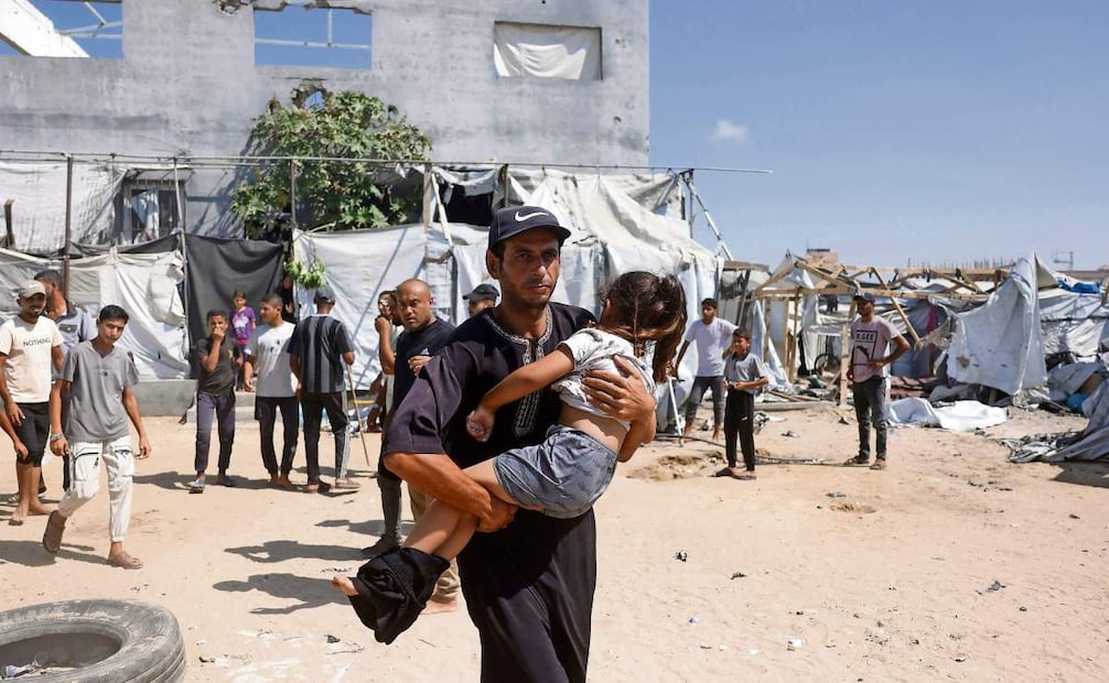 Un palestino lleva a una menor en brazos tras un ataque israelí en Mawasi, Khan Yunis, el lunes pasado. Foto: BASHAR TALEB/AFP