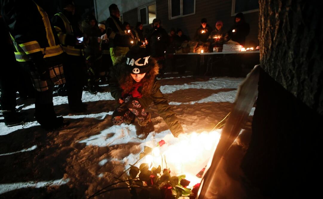 Cambria, hija de Morgan Harris, coloca una vela mientras se unía a la familia de tres víctimas en una vigilia en Manitoba. Foto: AP