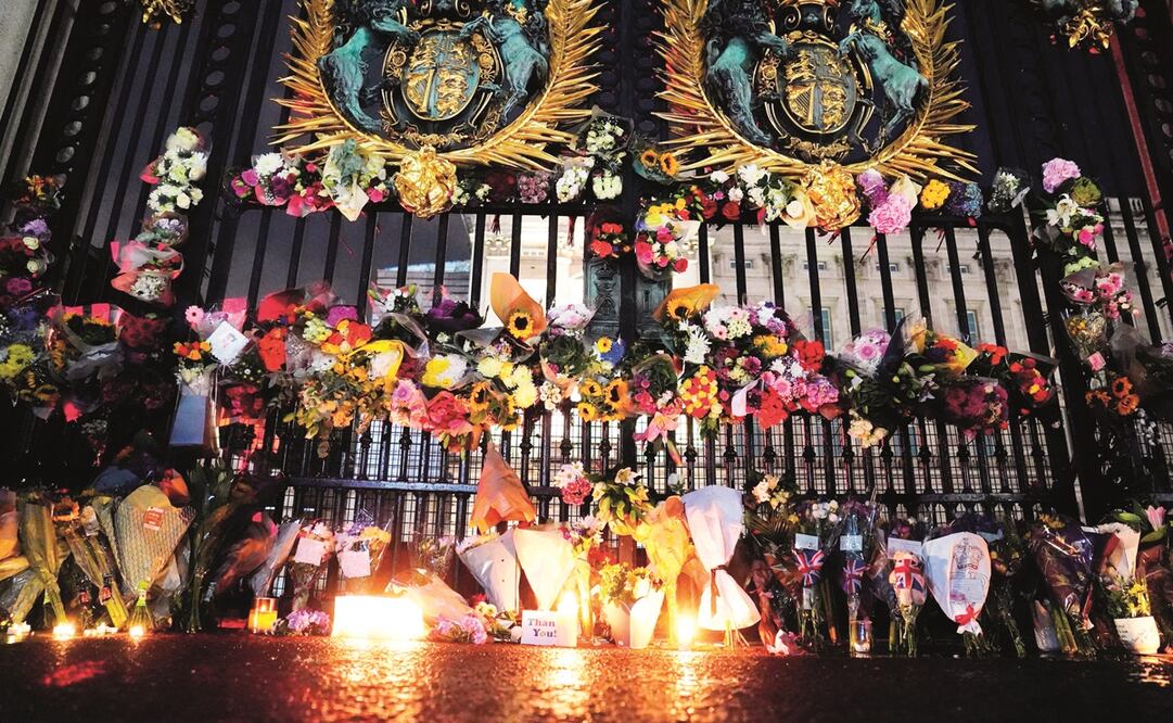 Tributes and candles left outside Buckingham Palace, in London, following the death of Queen Elizabeth II, Thursday, Sept. 8, 2022
