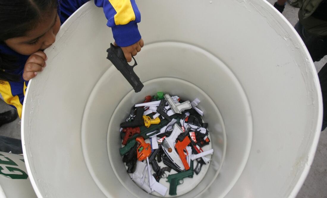 A child deposits her toy gun in exchange for a non-weapon-like toy as part of a government project - Photo: Mariana Bazo/REUTERS