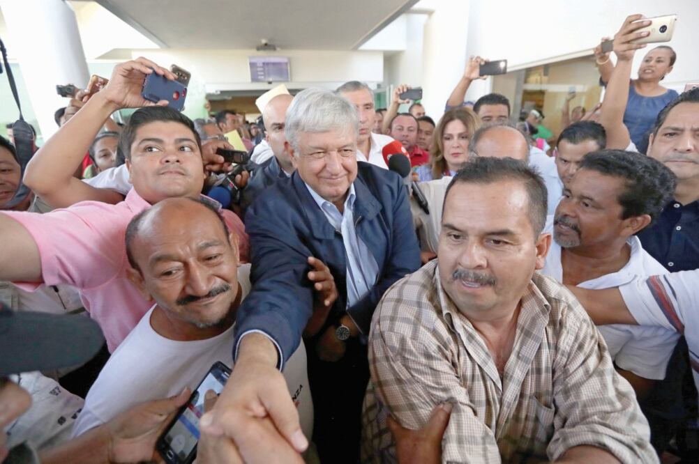 Un grupo de personas trata de abrirle el paso a López Obrador, tras su llegada al aeropuerto de Villahermosa. Foto: ARIEL OJEDA. EL UNIVERSAL
