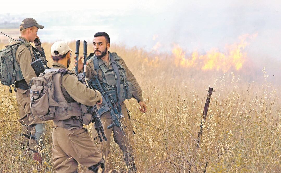 Soldados israelíes se encuentran frente a un incendio provocado por globos incendiarios lanzados desde la Franja de Gaza. Foto: JACK GUEZ. AFP