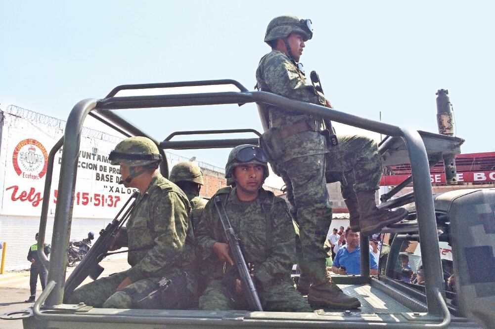 El número de mexicanos mayores de 18 años que se sienten inseguros en territorio nacional creció de 52.6 millones en 2011, a 58.3 millones en 2014. En la imagen, soldados vigilan Ecatepec, en el Estado de México (ARCHIVO EL UNIVERSAL)