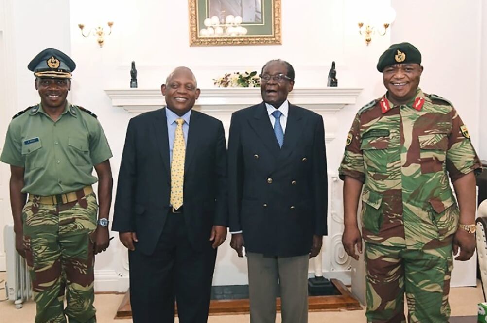 El diario The Herald difundió ayer imágenes en las cuales se ve al presidente Robert Mugabe (tercero de izquierda a derecha) conversando con el jefe del Estado Mayor, Constantino Chiwenga (último a la derecha), y mediadores. (AFP)