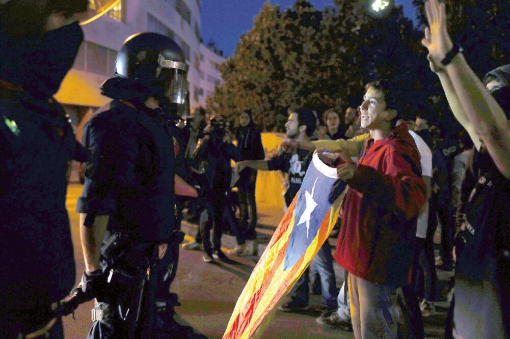 Unos 400 manifestantes trataron de impedir en Tarrasa que la Guardia Nacional sacara notificaciones electorales y tarjetas censales para el referéndum del 1 de octubre, que el gobierno español considera inconstitucional (TONI ALBIR. EFE)