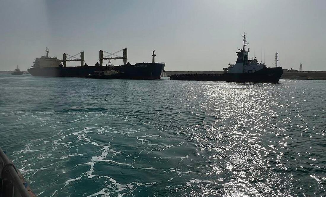 En esta imagen proporcionada por la Autoridad del Canal de Suez, el carguero Xin Hai Tong 23, a la izquierda, es remolcado tras quedar varado en el extremo sur del Canal de Suez. Foto: AP