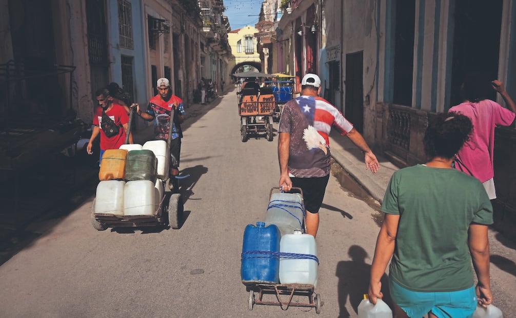 Varias personas transportan agua durante un apagón en La Habana, Cuba, el lunes 3 de agosto de 2026. Foto: Ramón Espinosa/ AP