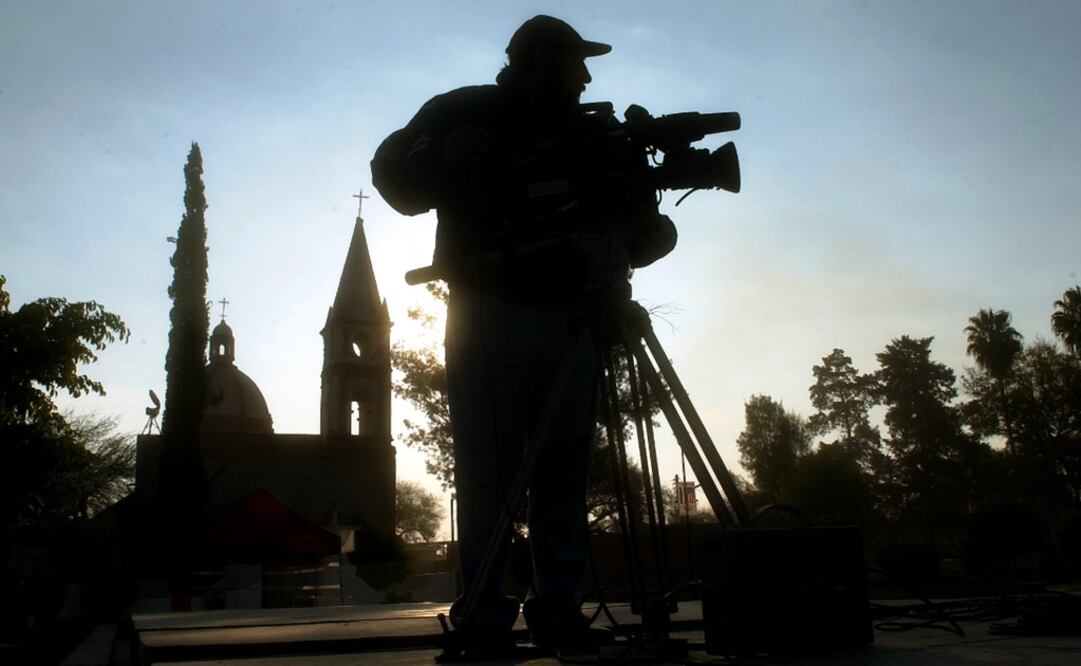 A Mexican cameraman adjusts his camera in front of the church in San Cristobal de los Ranchos - Photo: Gregory Bull/AP