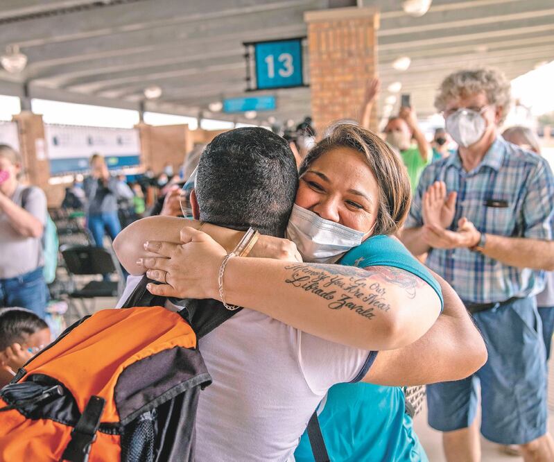 Un voluntario da la bienvenida a los solicitantes de asilo que cruzaron a EU desde un campamento de migrantes en México. Foto: JOHN MOORE. AFP