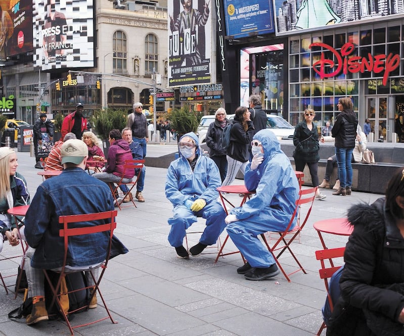 Dos personas con trajes protectores en Times Square, Nueva York. El gobernador Andrew Cuomo anunció ayer el despliegue de la Guardia Nacional a un suburbio de la ciudad. JUSTIN LANE. EFE