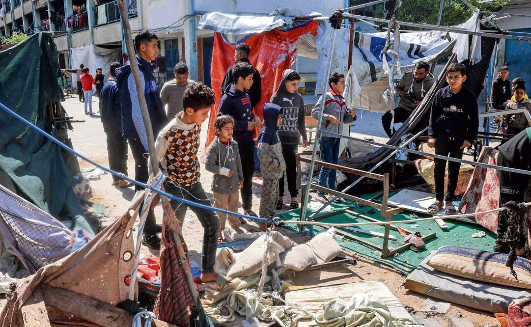 Niños palestinos revisan lo que quedó de un campamento tras un ataque israelí en Gaza. (25/03/2025) Foto: Eyad Baba | AFP