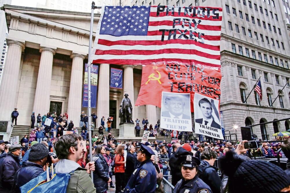Manifestantes expresaron ayer en Nueva York su rechazo a la reforma fiscal de Trump y acusaron al mandatario de traición por el Rusiagate. (EDUARDO MUÑOZ. REUTERS)
