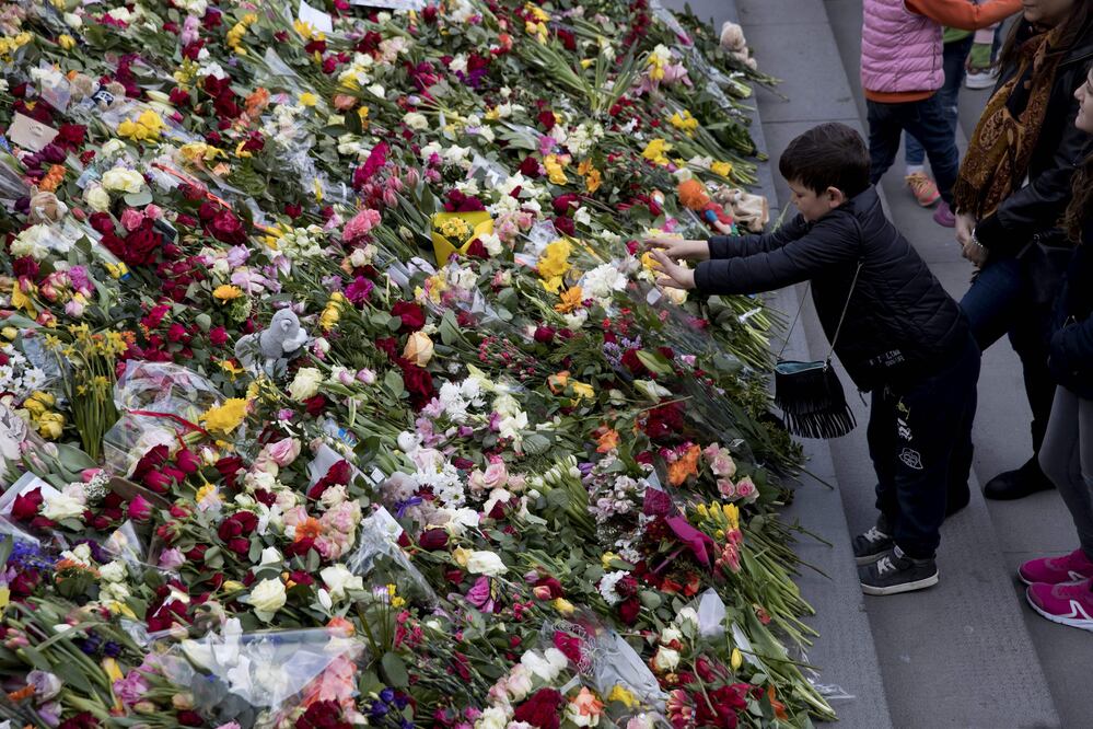 Un niño deposita una flor durante una vigilia por la paz en tributo a las victimas de un ataque con un camión en Estocolmo (Foto: Xinhua)