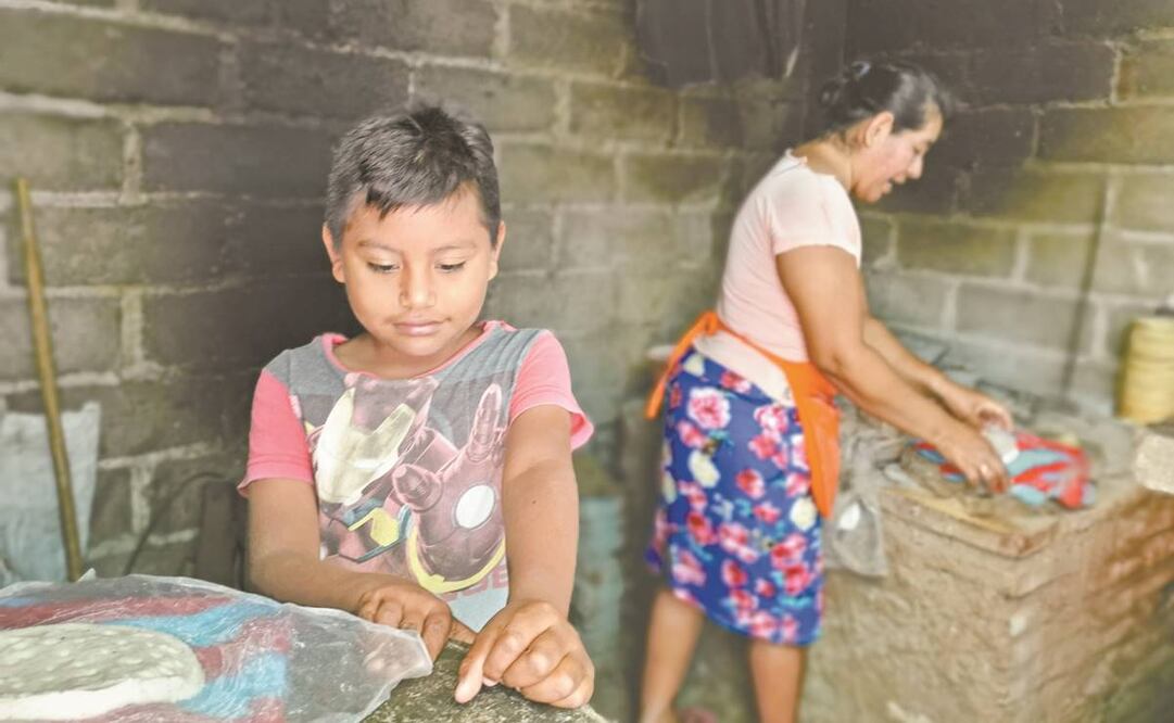El pequeño Eliel le ayuda a su madre, Nolberta, con los detalles de la preparación de totopos de maíz, los cuales vende para contribuir con el gasto familiar. Foto: Roselia Chaca. EL UNIVERSAL