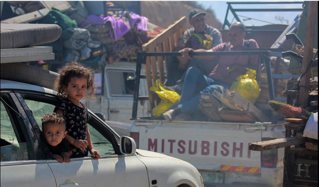 Un par de niños a bordo de un auto se desplazan hacia el sur desde Wadi Gaza, tras el anuncio israelí del cierre de la carretera de Al-Rashid hacia el norte de la asediada Franja de Gaza, el 1 de octubre de 2025. Foto: AFP