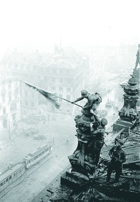 Un soldado ondea la bandera soviética en lo alto del Reichstag, en Berlín, en esta imagen legendaria captada por el fotógrafo del Ejército Rojo, Yevgeny Khaldei (YEVGENY KHALDEI / AP / ITAR-TASS)