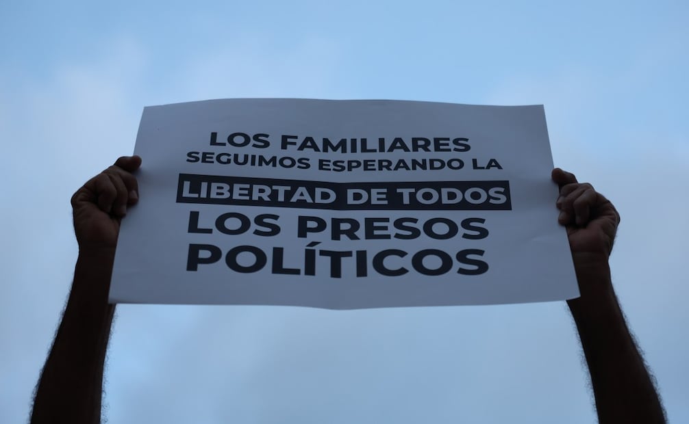 Una persona sostiene un cartel afuera de El Helicoide este sábado, en Caracas (Venezuela). Los familiares de los presos políticos en Venezuela se mantienen a la espera de excarcelaciones y a pesar del "desgaste físico y emocional" que aseguran sentir tras más de 48 horas de que las autoridades anunciaran la liberación de un "número importante" de estos detenidos. Foto: EFE