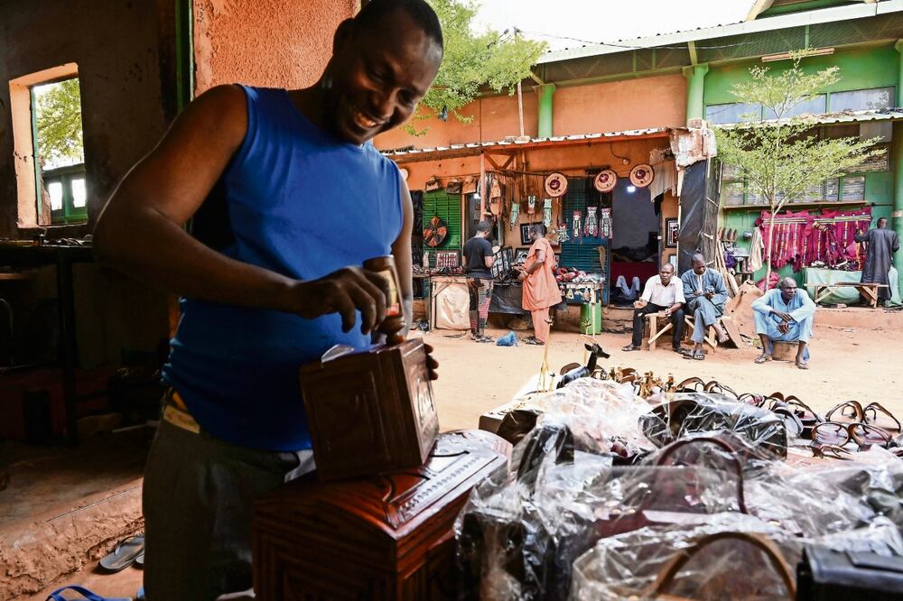 Un artesano pule su trabajo en su trabajo en Niamey. El país sufrió un golpe de Estado en julio pasado. Foto: AFP