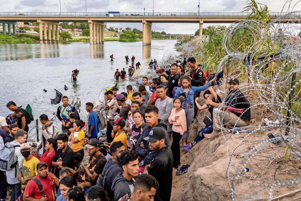 Los solicitantes de asilo esperan ser procesados ​​por agentes de la Patrulla Fronteriza de Estados Unidos después de cruzar el río Grande desde México hacia EU. Foto: John Moore | AFP
