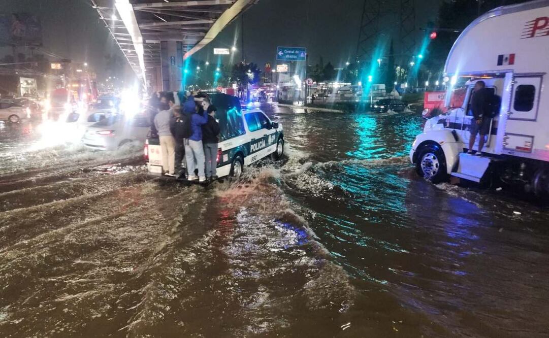 Policías ayudan en el traslado de personas por inundaciones. Foto: Especial.